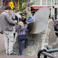 Kids playing on a giant ships propellor in the Scheepvaartbuurt at the Haarlemmerstraat