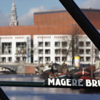 Name plate on the bridge and the opera house and Zuiderkerk in the distance.