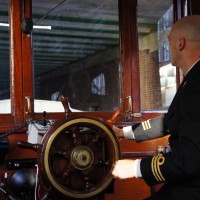 Kapitein Douwe manning the helm of the Saloon Boat "Ondine"