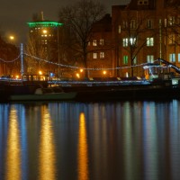 Ship (houseboat) on the Amstel decorated for the holidays. Okura Hotel behind it.