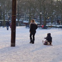 More wintersports. Mom taking kids on a sled ride across the Amstelveld park.