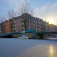 Frozen Amsterdam canal, early winter morning sun.