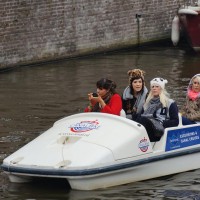 American girls looking fabulous, putting on makeup while navigating through the tourboats in a peddle boat.