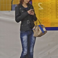 Beautiful girl waiting for the train and texting